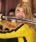 Fotomontaje en el que poner una cara a Uma thurman en Kill Bill. Aparece con su mítico mono de motorista colores amarillo limón y negro, sosteniendo una katana en actitud amenazante, está rodeada por miembros de la Yakuza, de los cuales podemos ver unos cuantos vestidos de traje con antifaces en segundo plano, desenfocados, integrando el